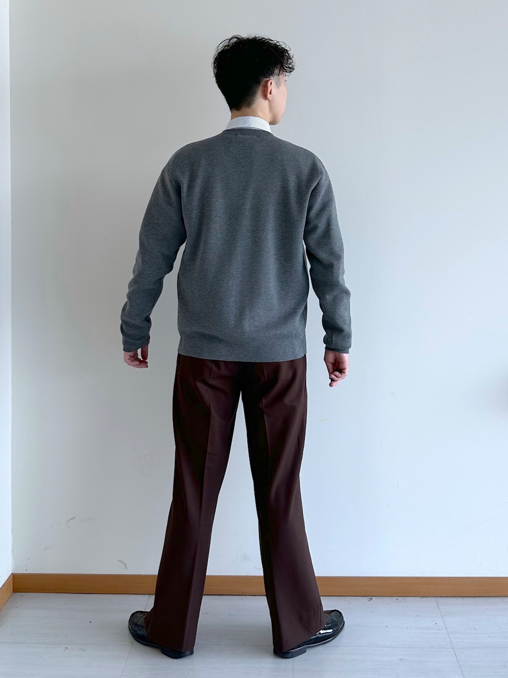グレー系のカーディガン/ボレロ、ブルー系のシャツ/ブラウス、ブラウン系のスラックスを着用したメンズの秋コーディネートの4枚目の写真