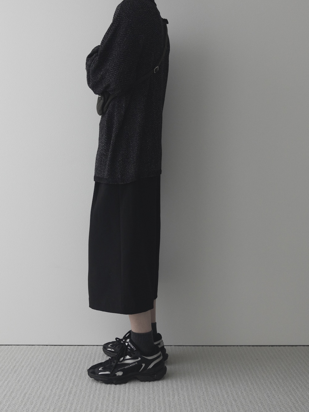 ブラック系のポロシャツ、ブラック系のスニーカーを着用したメンズの春コーディネートの2枚目の写真