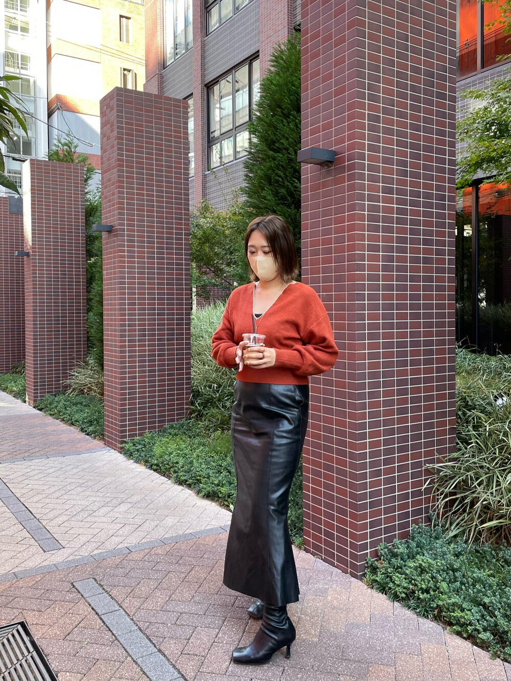 ブラック系のスカート、ブラウン系のニット/セーターを着用したレディースの秋コーディネートの2枚目の写真