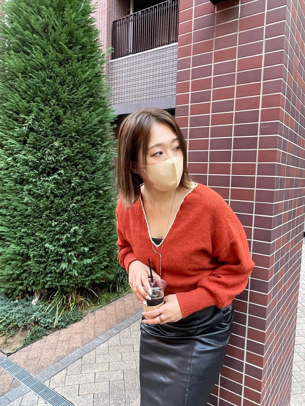 ブラック系のスカート、ブラウン系のニット/セーターを着用したレディースの秋コーディネートの3枚目の写真