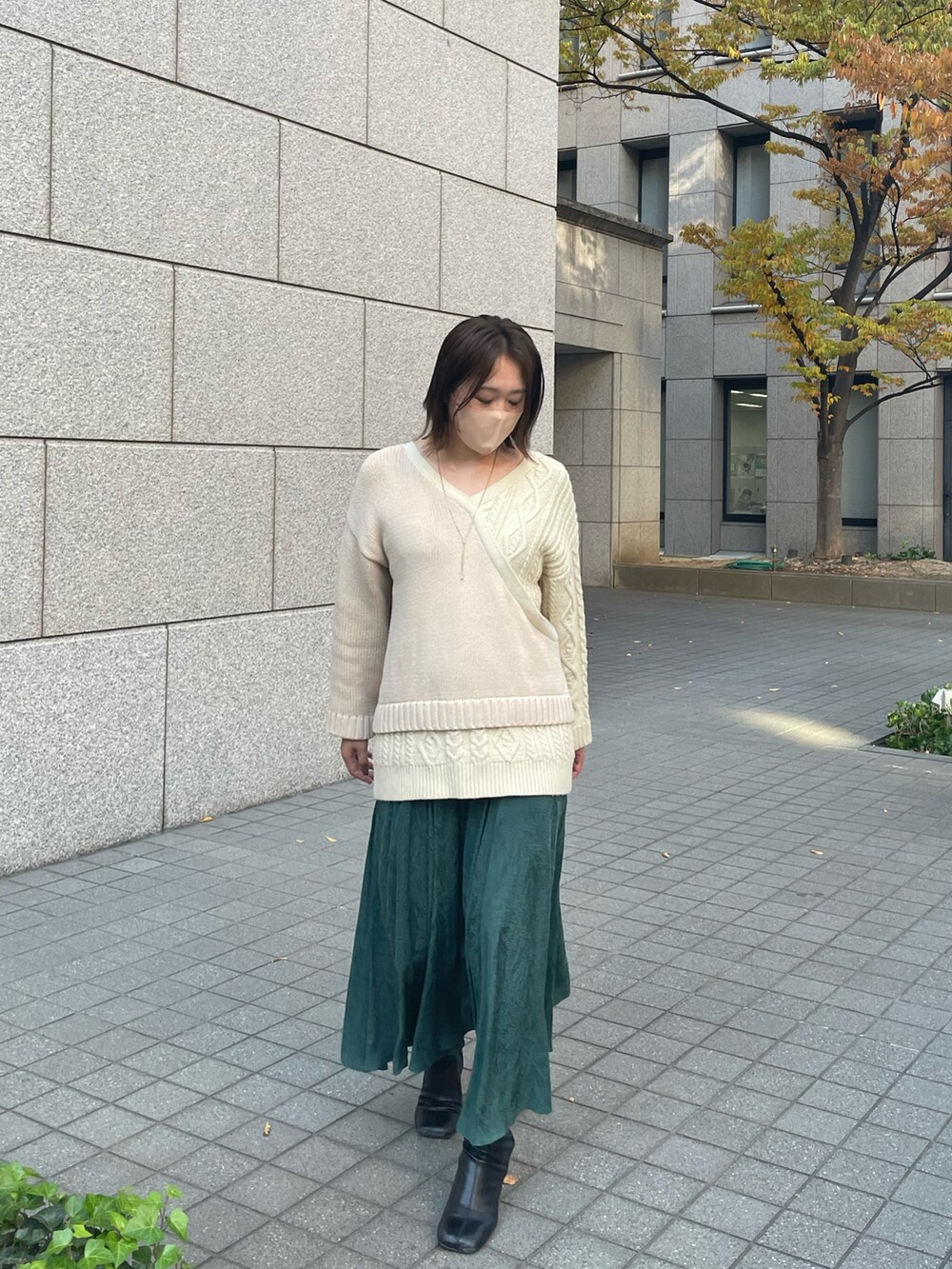 ホワイト系のニット/セーター、グリーン系のスカートを着用したレディースの秋コーディネートの2枚目の写真