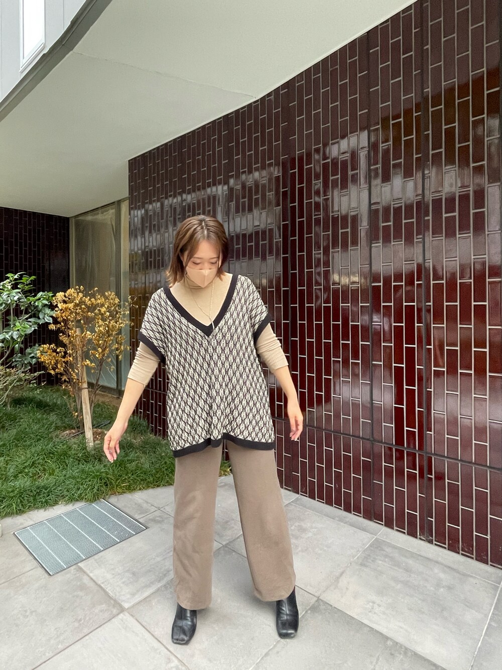 ブラック系のベストを着用したレディースの秋コーディネートの2枚目の写真