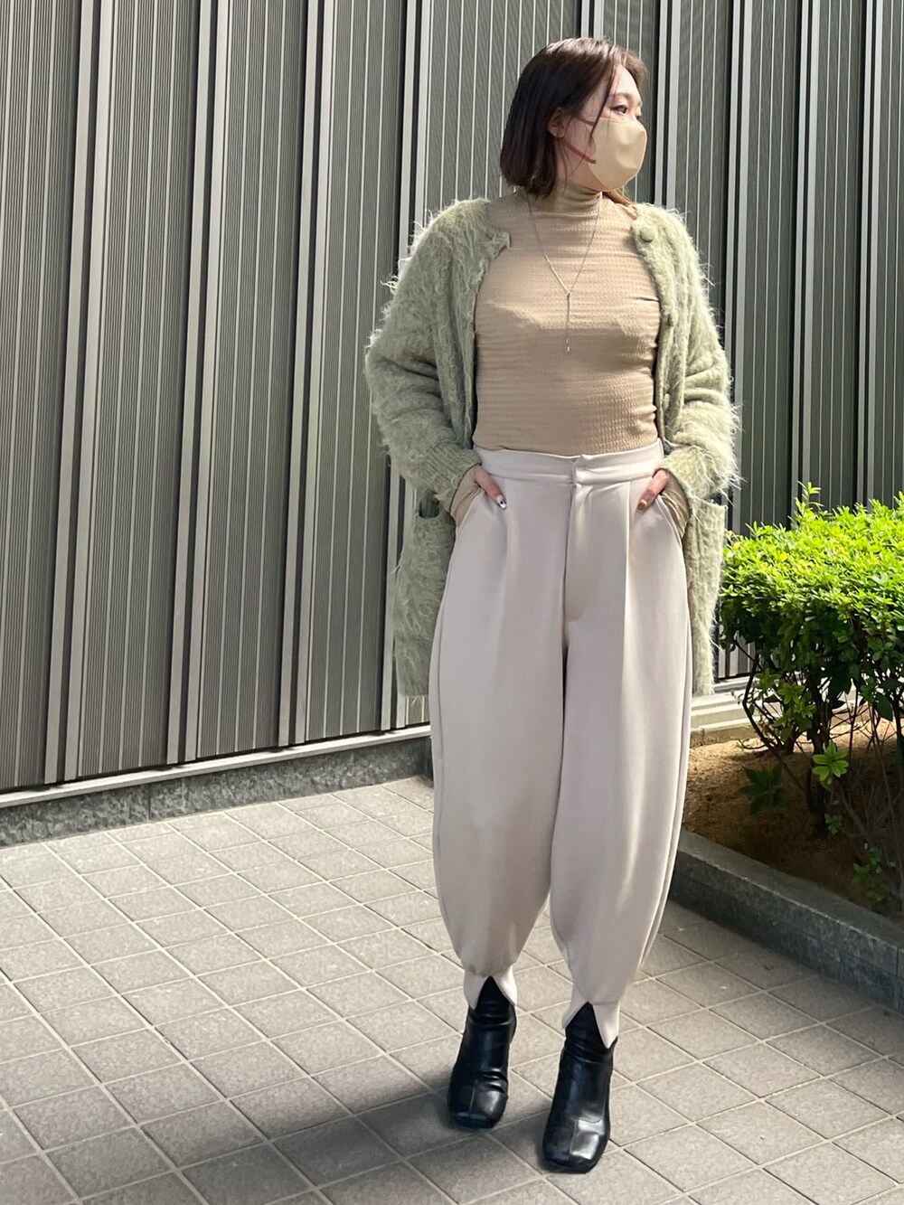 ベージュ系のTシャツ/カットソー、ベージュ系のその他パンツ、グリーン系のカーディガン/ボレロを着用したレディースの秋コーディネートの2枚目の写真