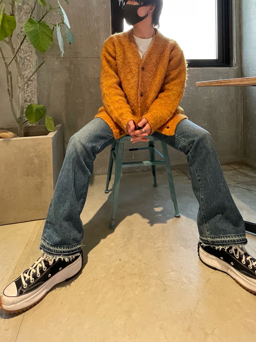 イエロー系のカーディガン/ボレロ、ブルー系のデニムパンツを着用したメンズの冬コーディネートの2枚目の写真