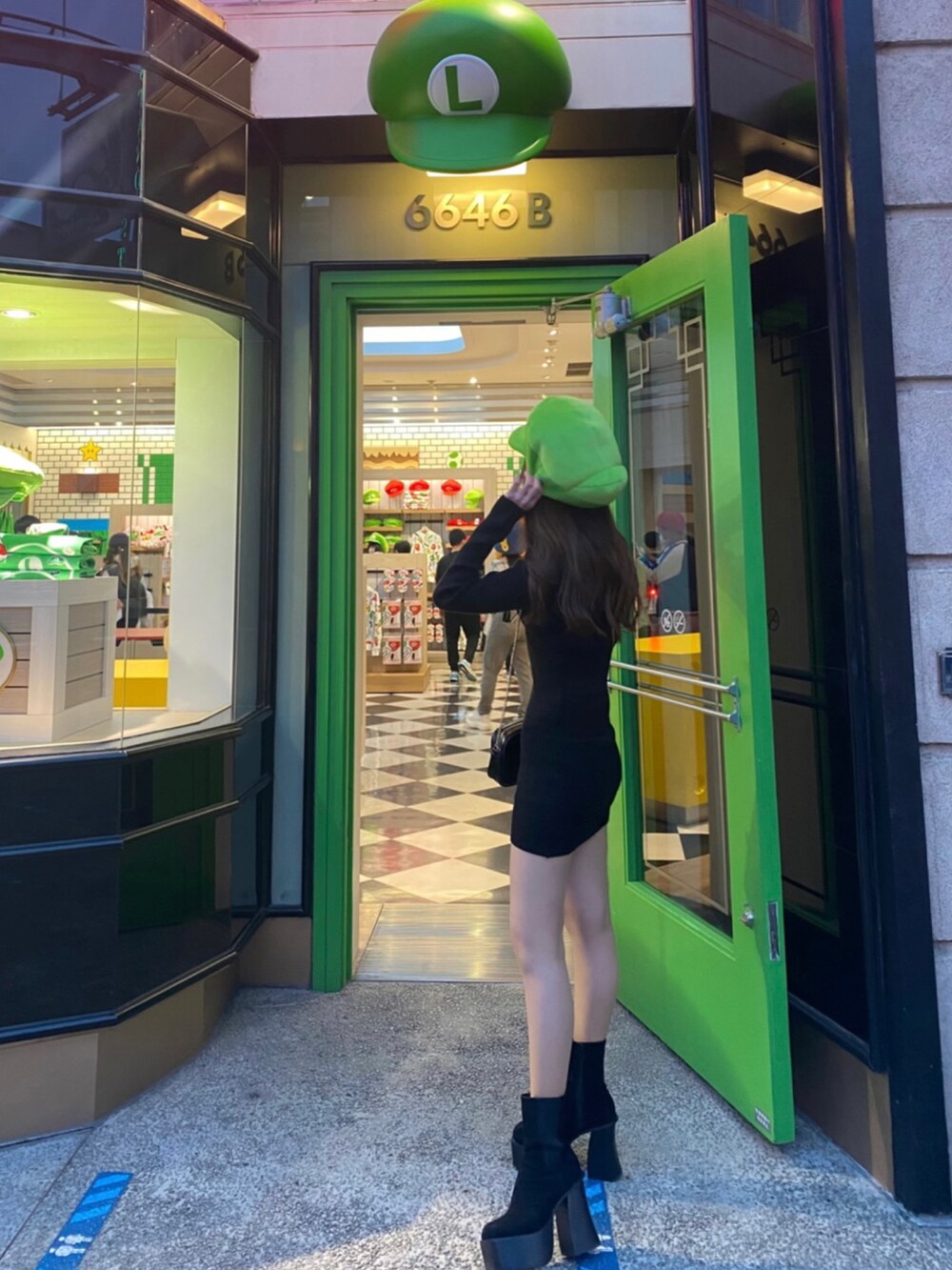 ブラック系のブーツ、ブラック系のワンピースを着用したレディースの夏コーディネートの3枚目の写真