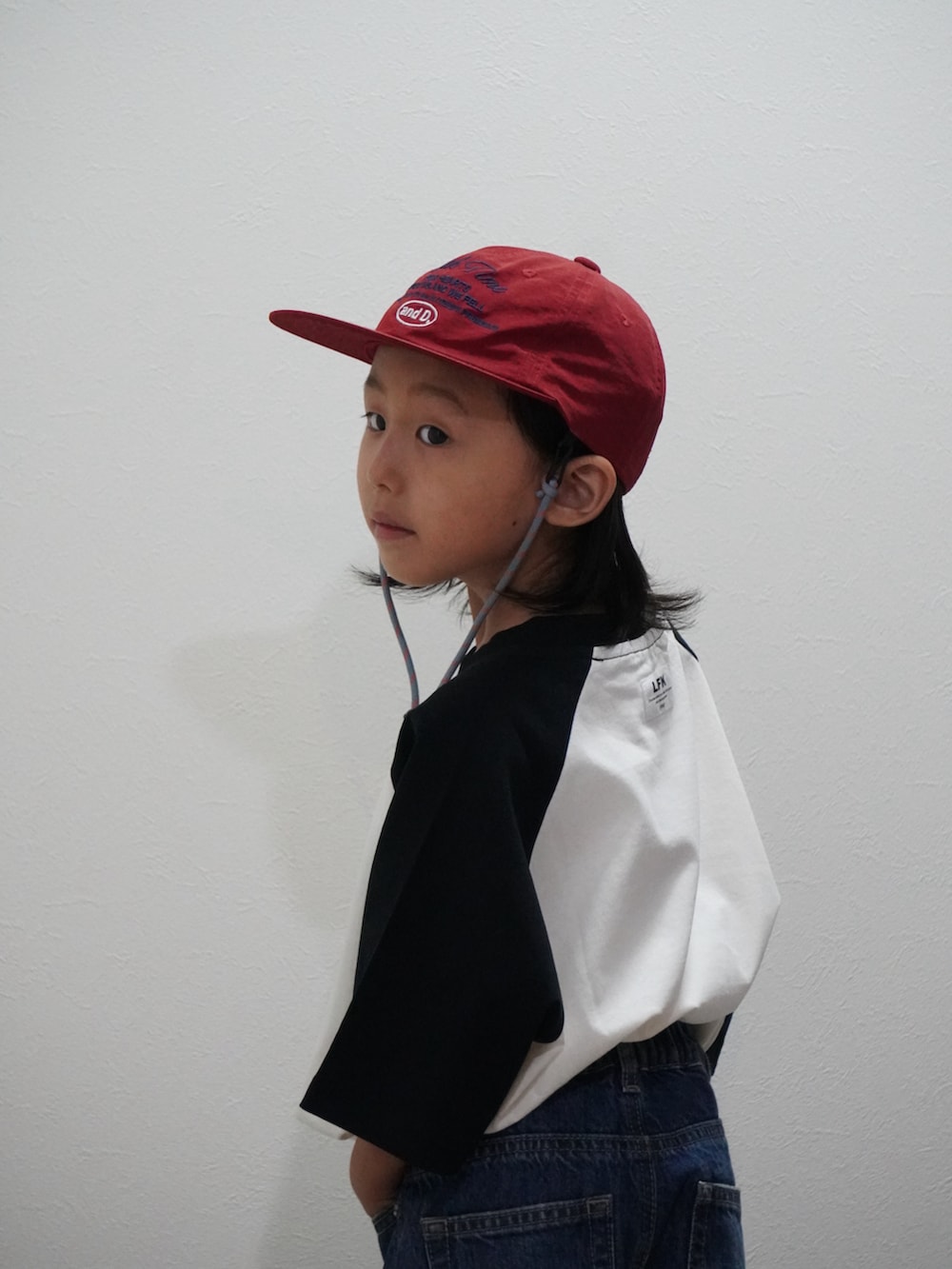 ブルー系のデニムパンツ、ベージュ系のTシャツ/カットソー、ホワイト系のスニーカーを着用したキッズの夏コーディネートの4枚目の写真