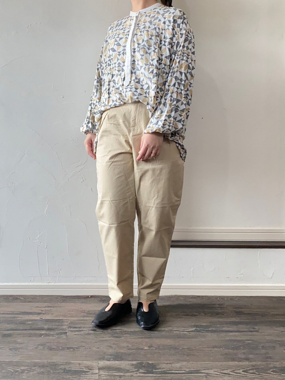 ブラック系のパンプス、ブラウン系のシャツ/ブラウス、ベージュ系のチノパンツを着用したレディースの春コーディネートの2枚目の写真
