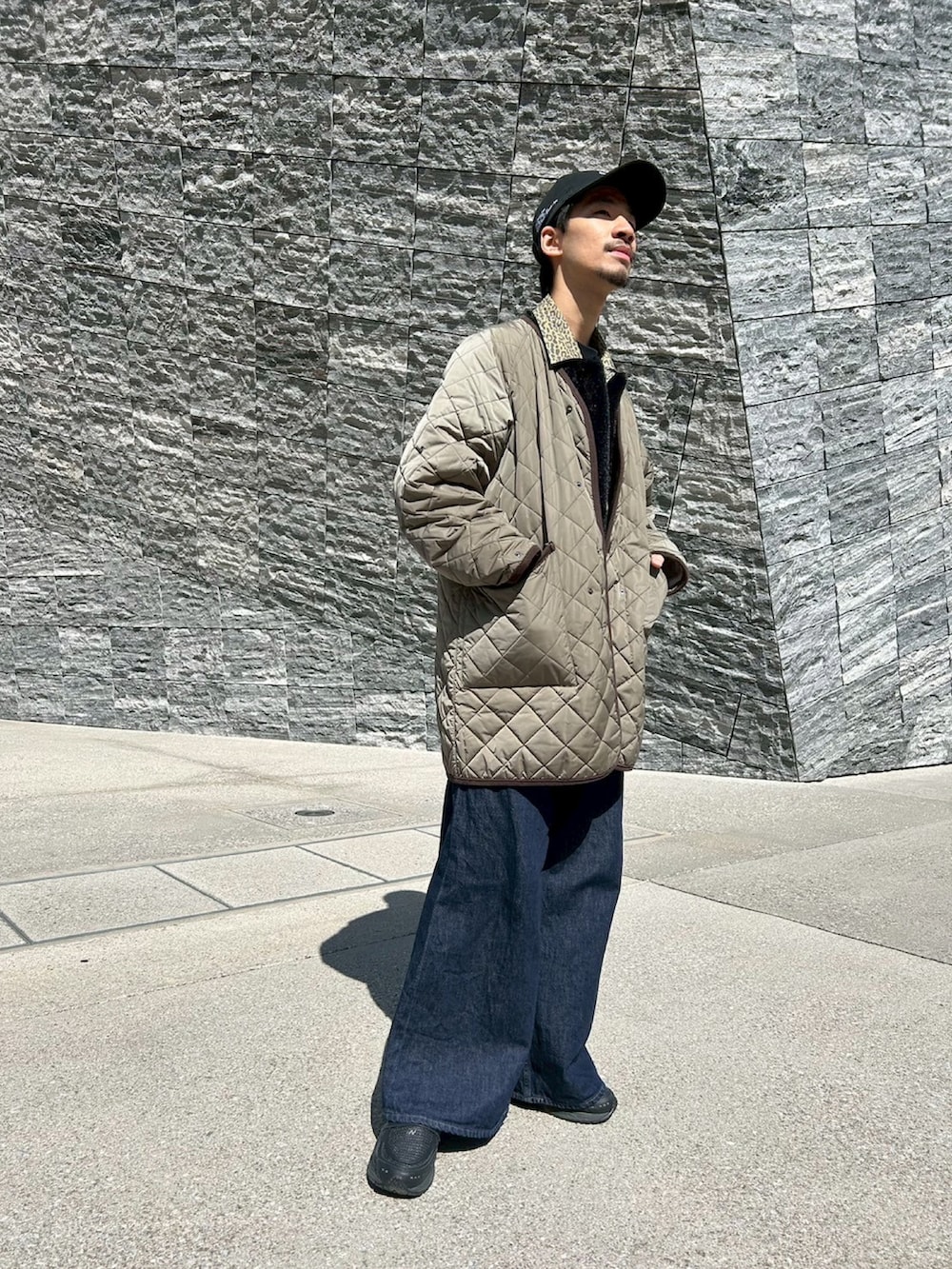 グリーン系のノーカラーコート、ブルー系のデニムパンツ、ブラック系のローファーを着用したメンズの春コーディネートの2枚目の写真