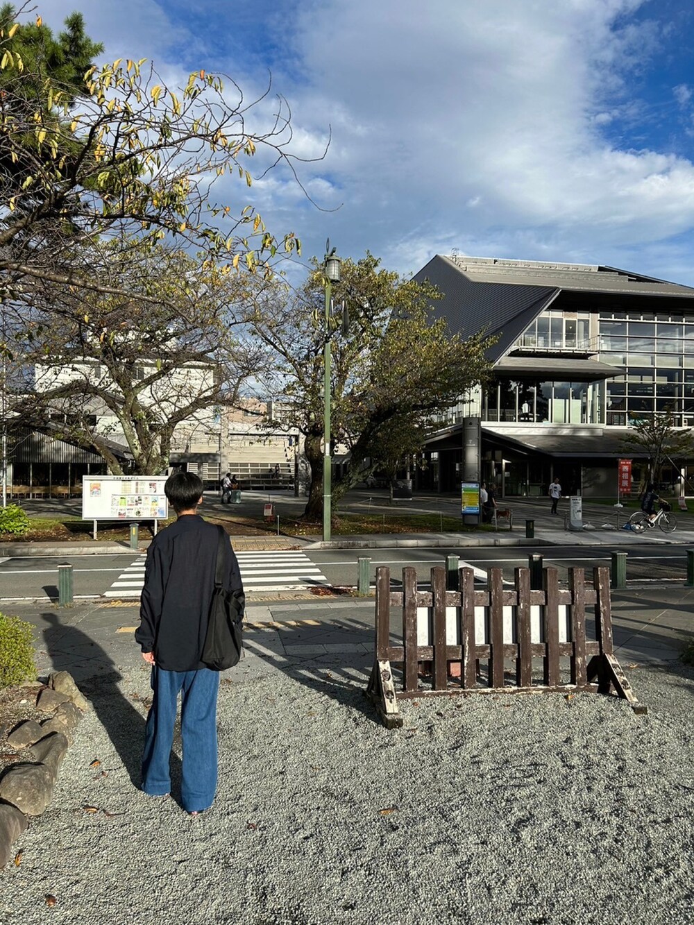 ブルー系のシャツ/ブラウス、ブラック系のバッグ、ブルー系のデニムパンツを着用したメンズの秋コーディネートの3枚目の写真