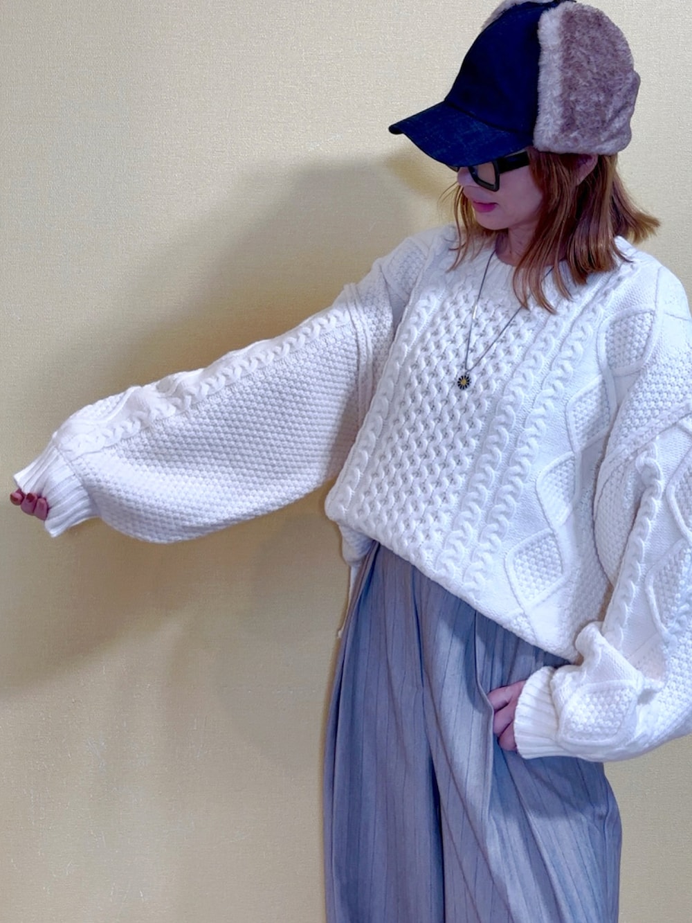 ホワイト系のニット/セーター、ベージュ系のその他パンツ、ブラック系のショルダーバッグを着用したレディースの秋コーディネートの4枚目の写真