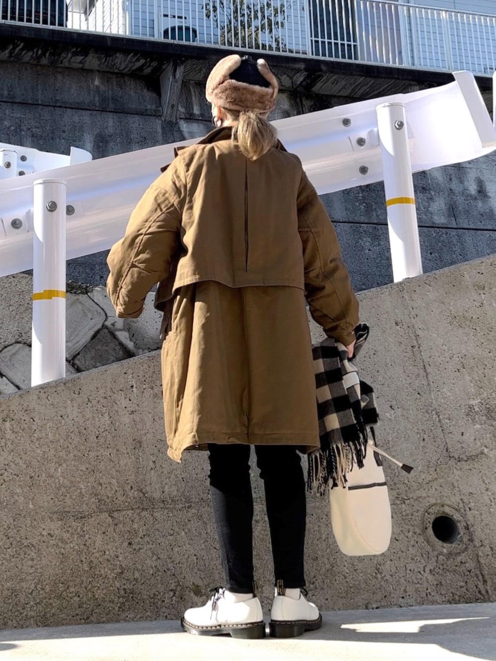 グリーン系のミリタリージャケット、ホワイト系のTシャツ/カットソー、ブラック系のデニムパンツを着用したレディースの冬コーディネートの3枚目の写真