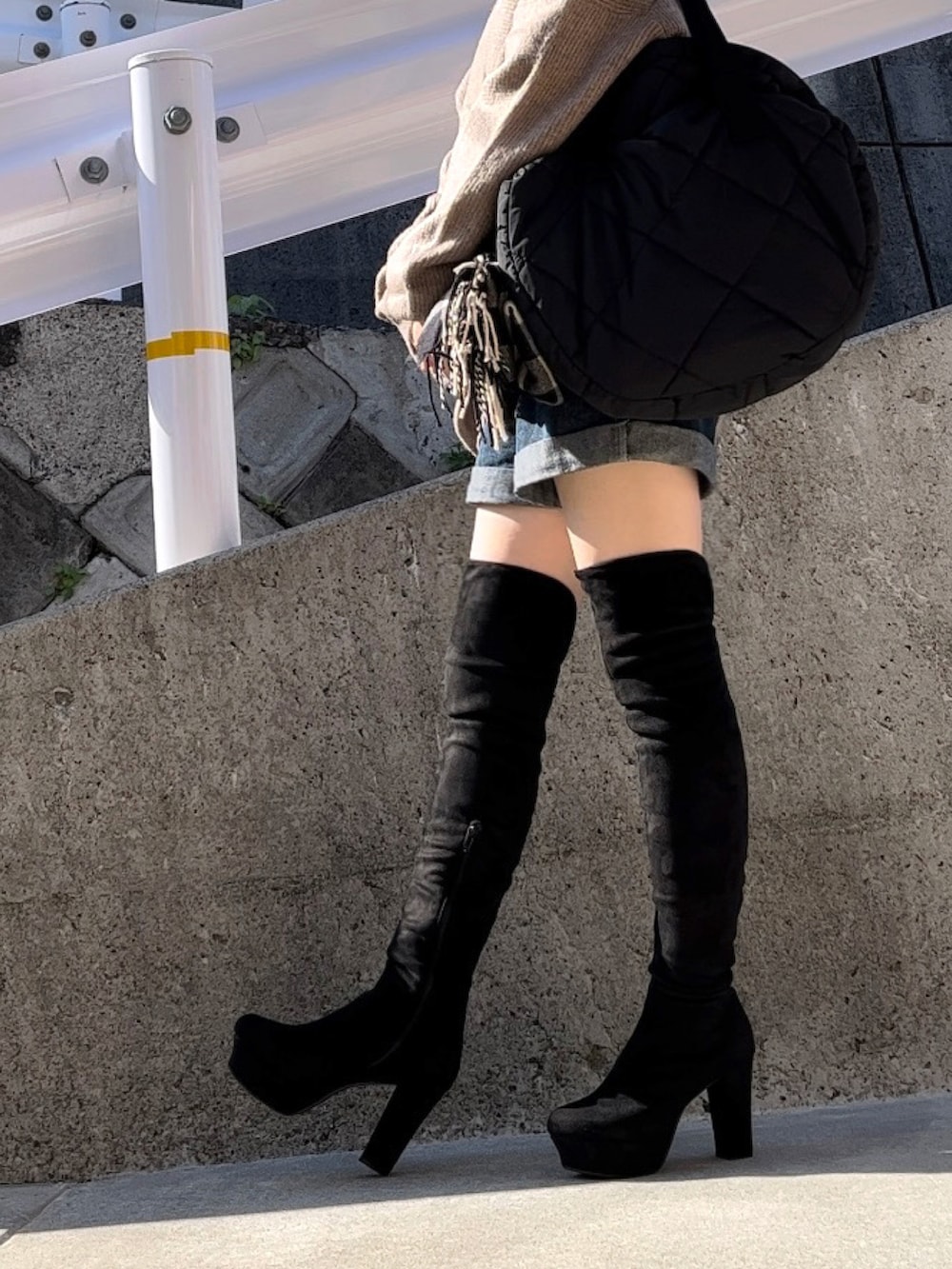 ベージュ系のニット/セーター、ブラック系のブーツ、ブラック系のTシャツ/カットソーを着用したレディースの秋コーディネートの3枚目の写真