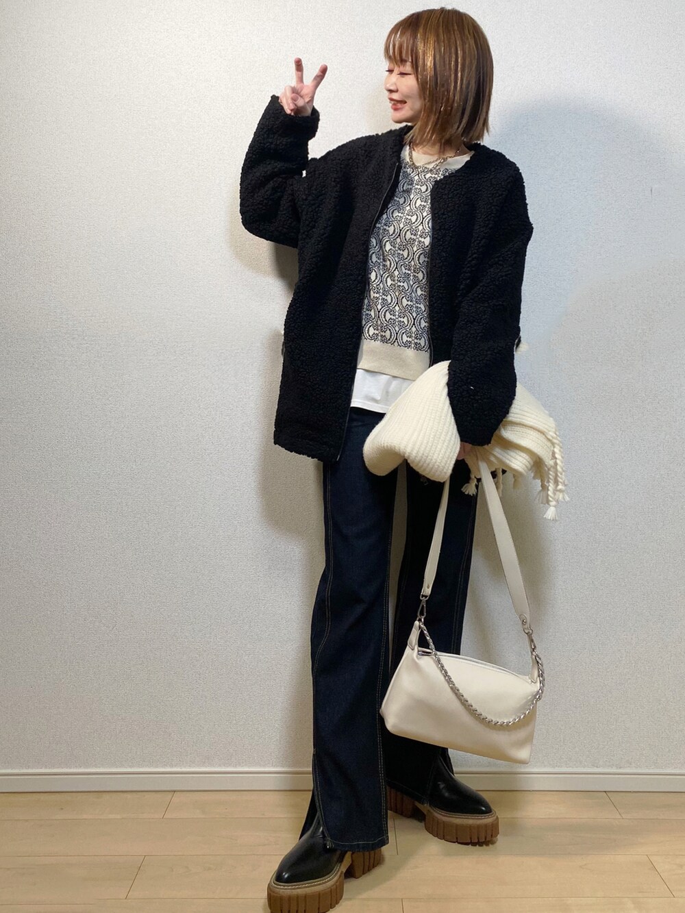 ホワイト系のカーディガン/ボレロ、ブルー系のデニムパンツ、ブラック系のジャケット/アウターを着用したレディースの冬コーディネートの2枚目の写真