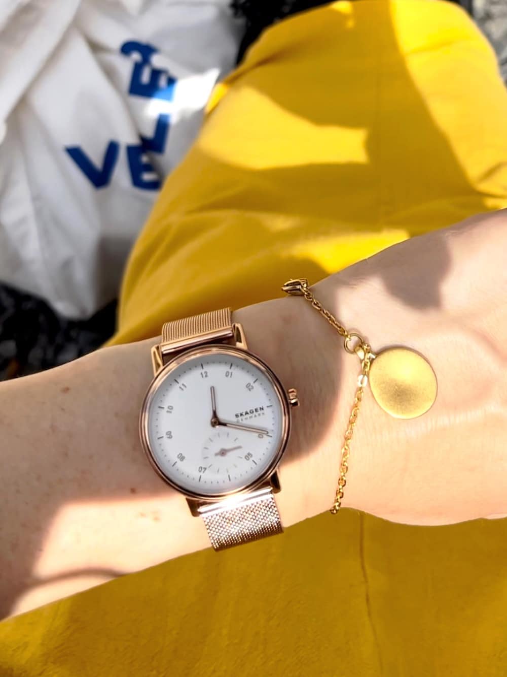 ブラック系のパーカー、イエロー系のスカート、ホワイト系のバッグを着用したレディースの秋コーディネートの3枚目の写真