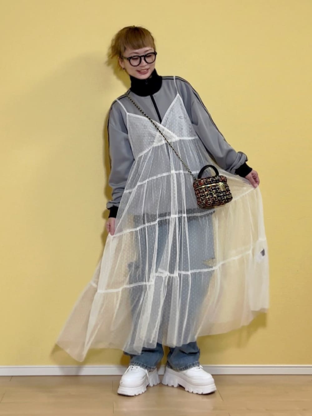 グレー系のジャージ、ブラック系のバッグ、ブルー系のデニムパンツを着用したレディースの冬コーディネートの2枚目の写真