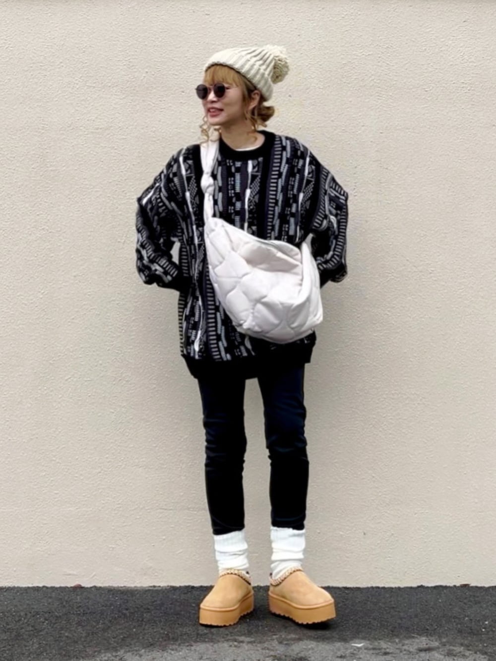 ブラック系のニット/セーター、ホワイト系のショルダーバッグ、ベージュ系のシューズを着用したレディースの冬コーディネートの2枚目の写真