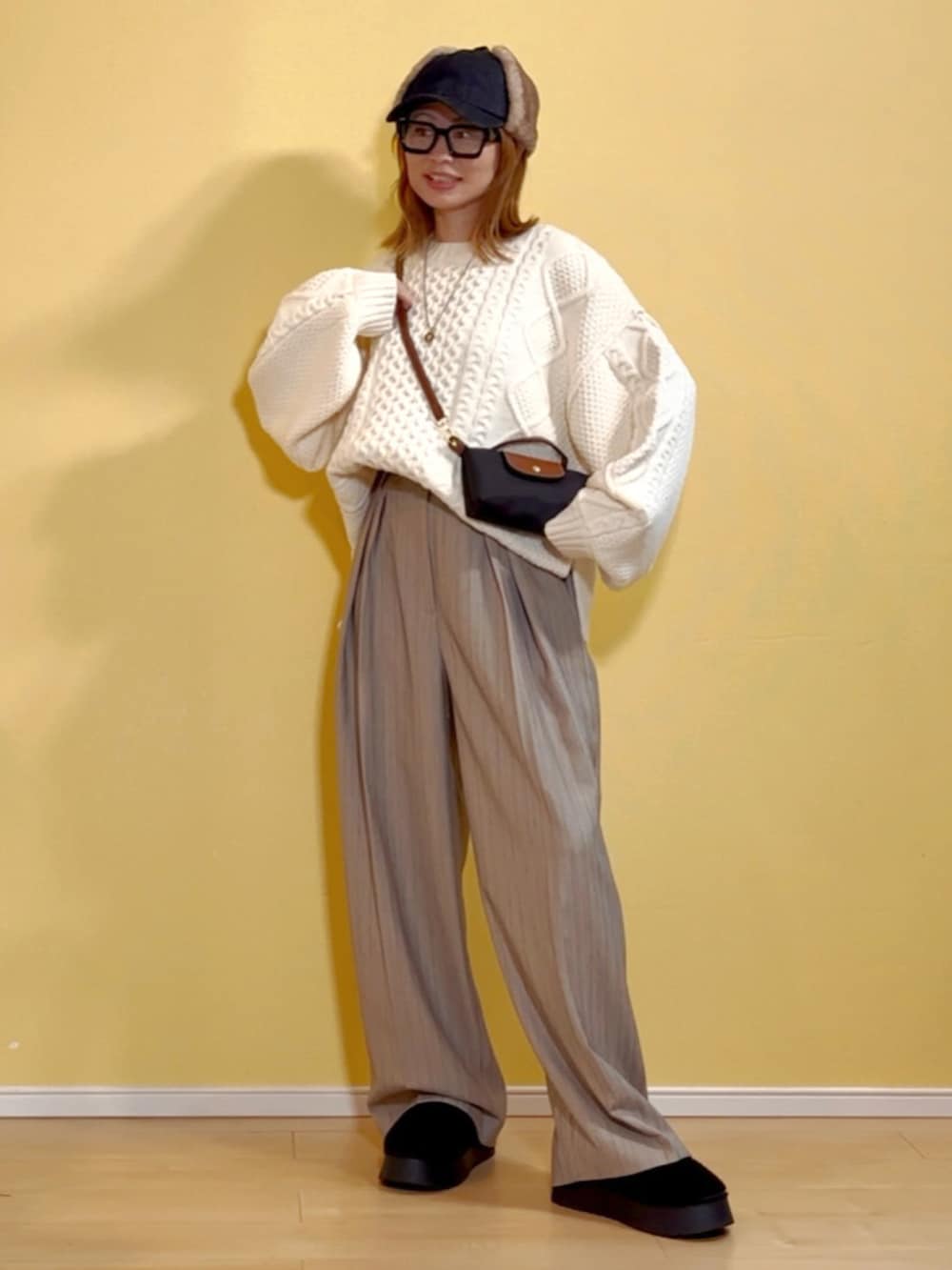 ホワイト系のニット/セーター、ベージュ系のその他パンツ、ブラック系のショルダーバッグを着用したレディースの秋コーディネートの2枚目の写真