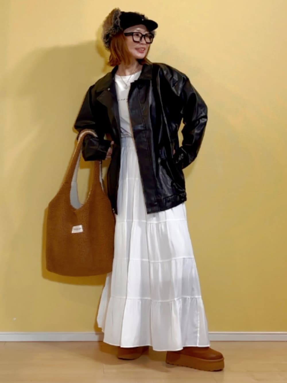 ブラック系のブルゾン、ホワイト系のスカート、ホワイト系のネックレスを着用したレディースの冬コーディネートの2枚目の写真