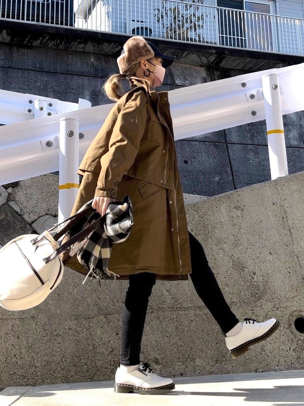 グリーン系のミリタリージャケット、ホワイト系のTシャツ/カットソー、ブラック系のデニムパンツを着用したレディースの冬コーディネートの2枚目の写真