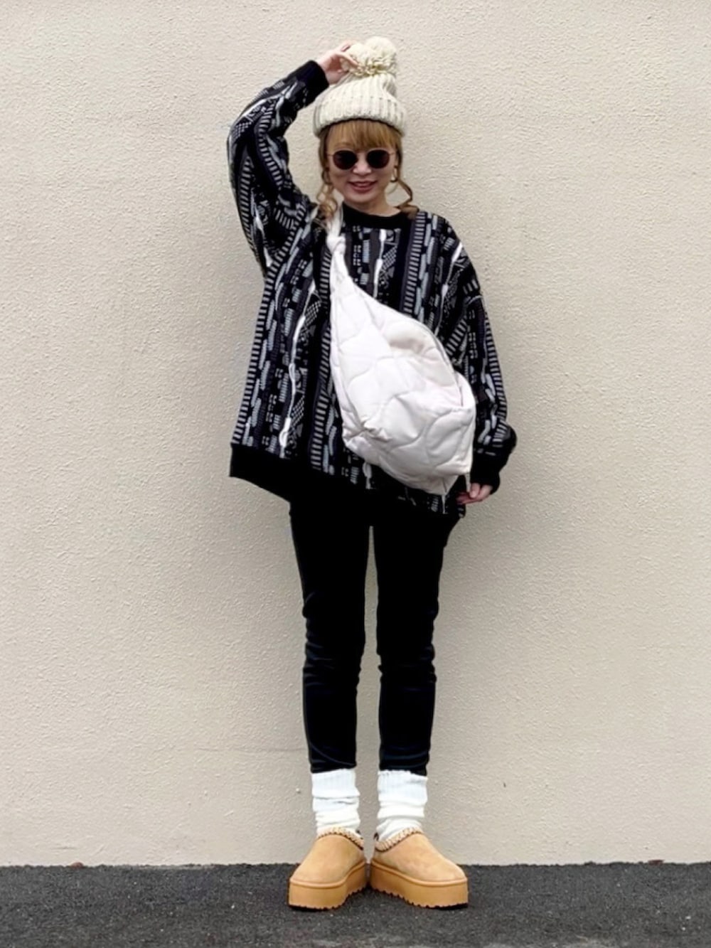 ブラック系のニット/セーター、ホワイト系のショルダーバッグ、ベージュ系のシューズを着用したレディースの冬コーディネートの4枚目の写真