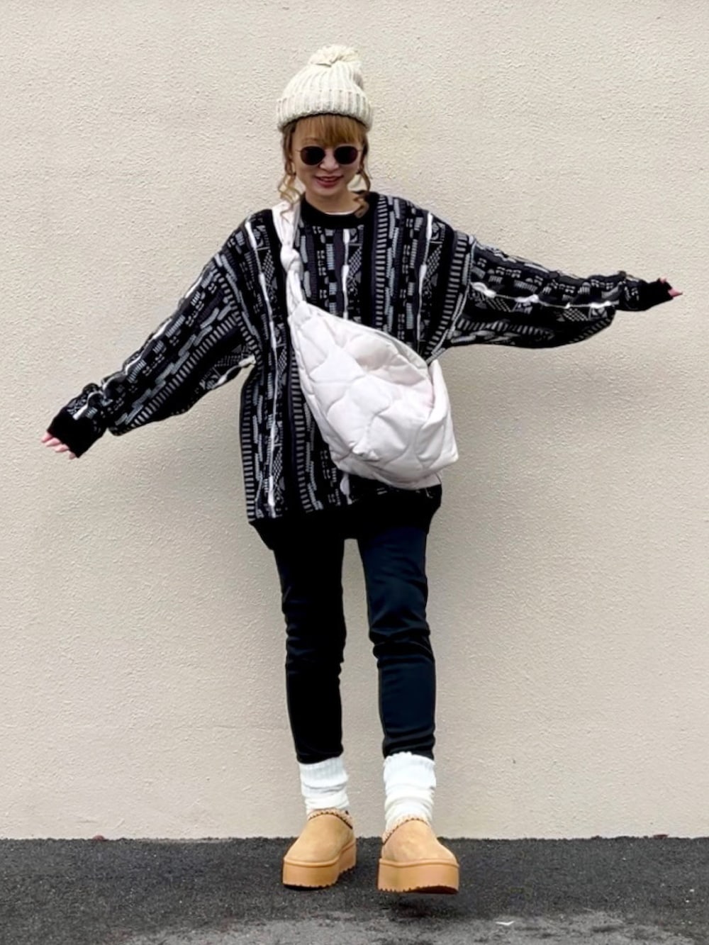 ブラック系のニット/セーター、ホワイト系のショルダーバッグ、ベージュ系のシューズを着用したレディースの冬コーディネートの5枚目の写真