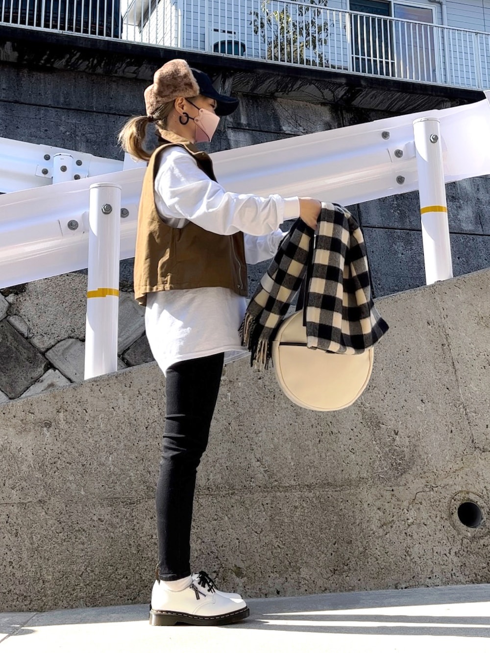 グリーン系のミリタリージャケット、ホワイト系のTシャツ/カットソー、ブラック系のデニムパンツを着用したレディースの冬コーディネートの5枚目の写真