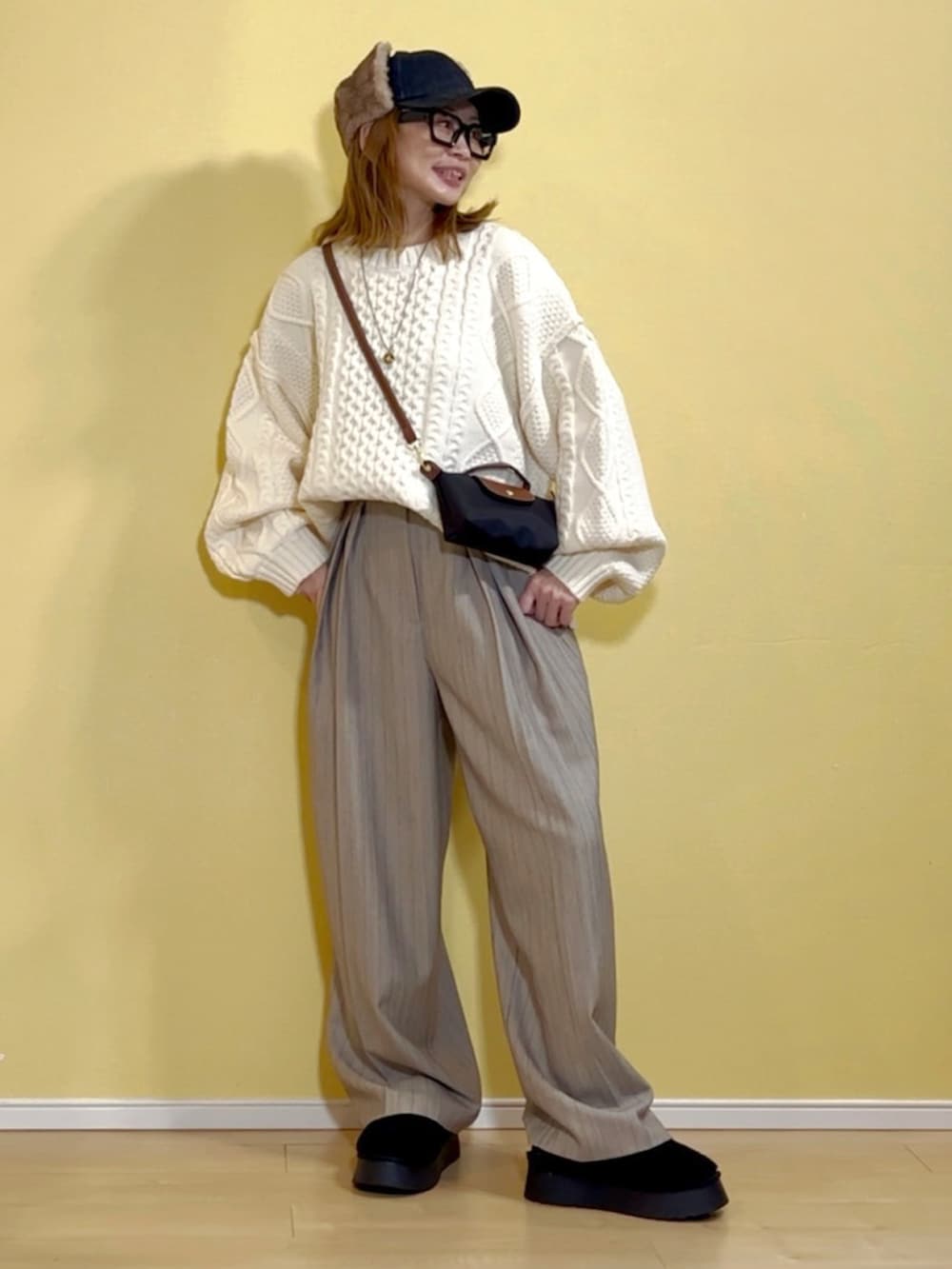 ホワイト系のニット/セーター、ベージュ系のその他パンツ、ブラック系のショルダーバッグを着用したレディースの秋コーディネートの3枚目の写真