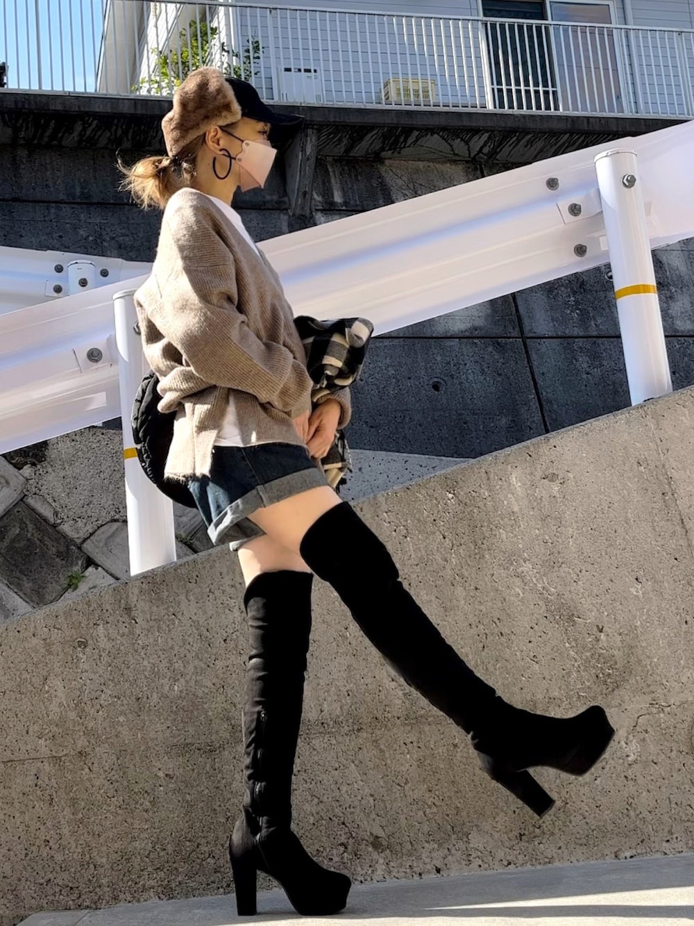 ベージュ系のニット/セーター、ブラック系のブーツ、ブラック系のTシャツ/カットソーを着用したレディースの秋コーディネートの2枚目の写真