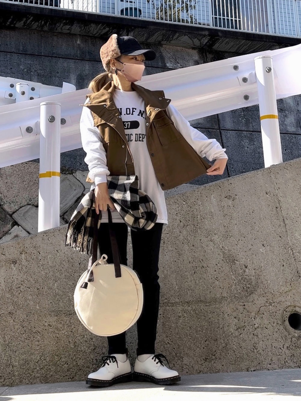 グリーン系のミリタリージャケット、ホワイト系のTシャツ/カットソー、ブラック系のデニムパンツを着用したレディースの冬コーディネートの4枚目の写真