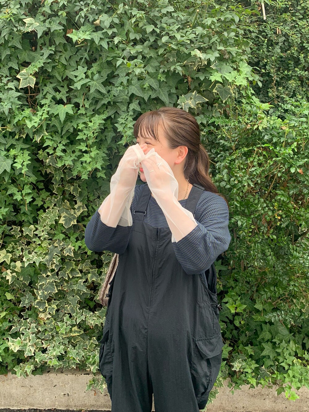 ブラック系のサロペット/オーバーオール、ゴールド系のショルダーバッグ、ブルー系のTシャツ/カットソーを着用したレディースの秋コーディネートの2枚目の写真