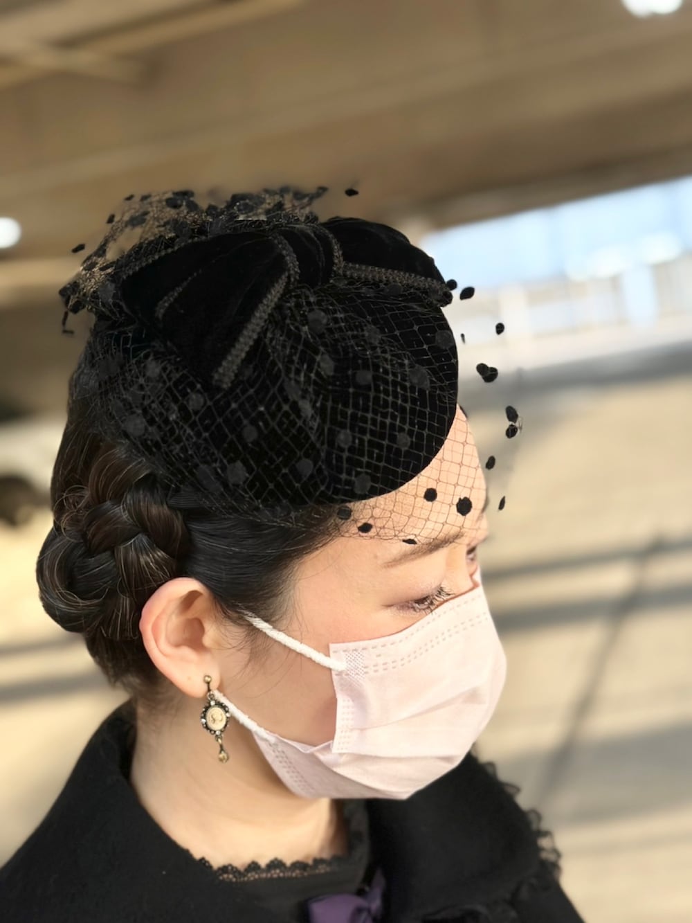 ブラック系のジャケット/アウター、パープル系のワンピース/ドレス、ブラック系のシューズを着用したレディースの冬コーディネートの2枚目の写真