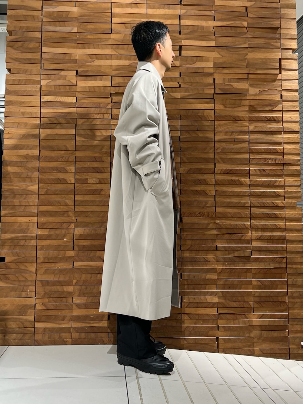 ブラウン系のシャツ/ブラウス、ベージュ系のステンカラーコート、ブラック系のその他パンツを着用したメンズの冬コーディネートの3枚目の写真