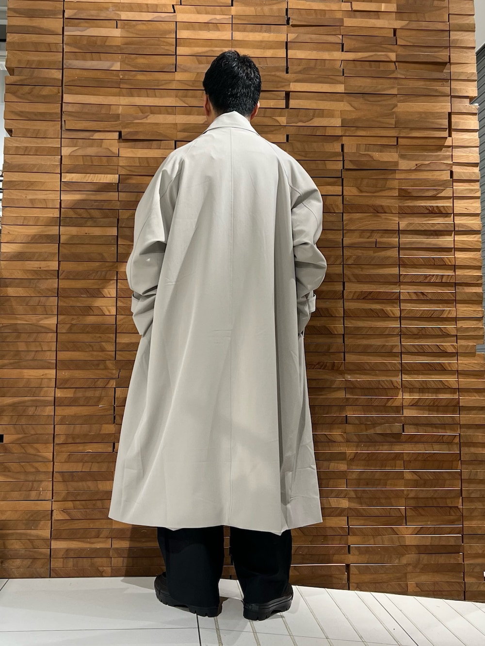 ブラウン系のシャツ/ブラウス、ベージュ系のステンカラーコート、ブラック系のその他パンツを着用したメンズの冬コーディネートの4枚目の写真