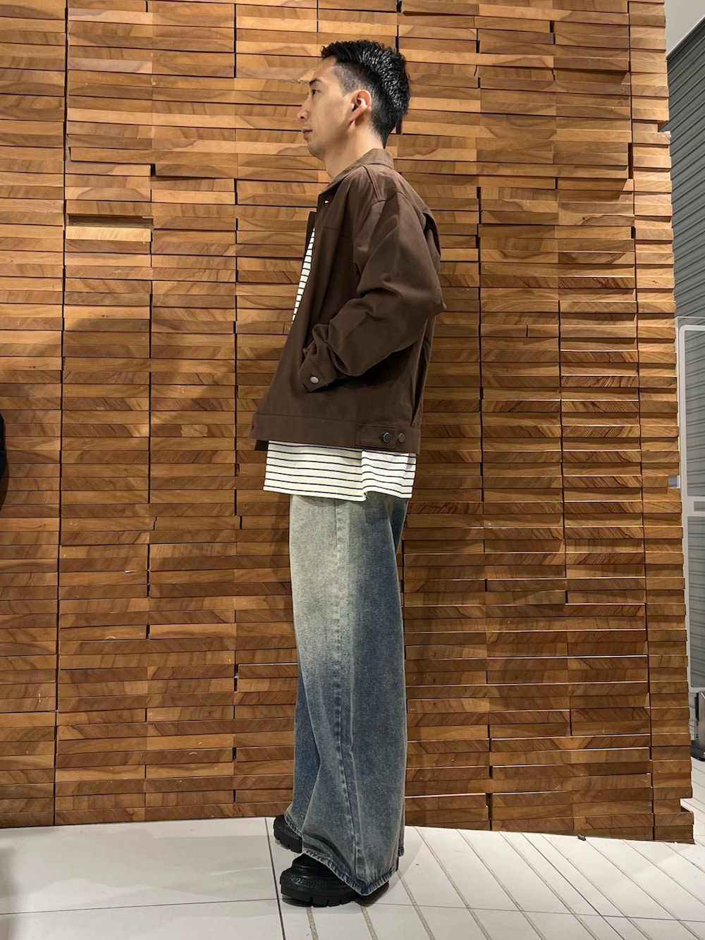 ホワイト系のTシャツ/カットソー、ブラウン系のブルゾン、ブルー系のデニムパンツを着用したメンズの春コーディネートの2枚目の写真