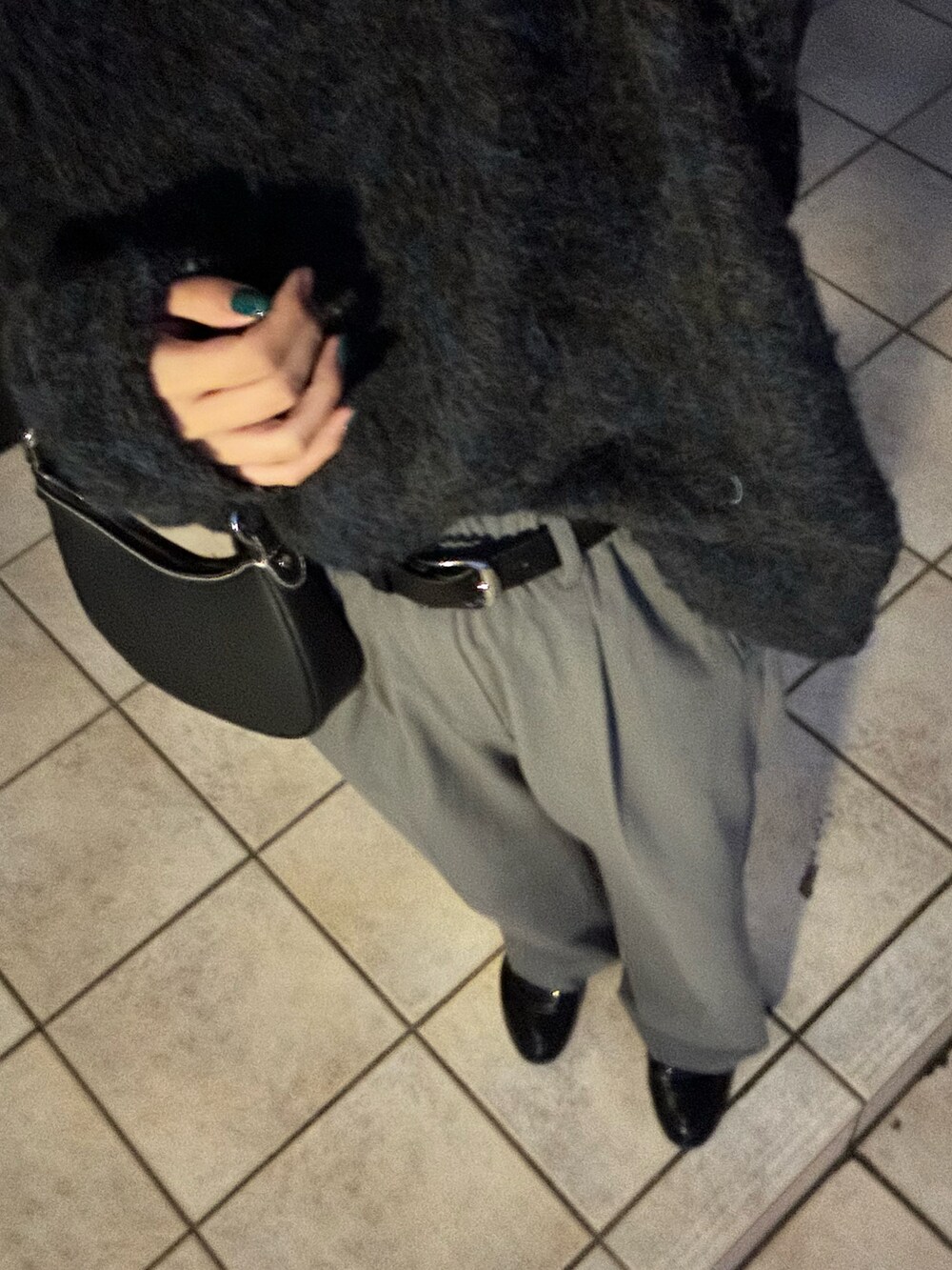 ブラック系のニット/セーター、グレー系のパンツ、ブラック系のベルトを着用したレディースの秋コーディネートの3枚目の写真