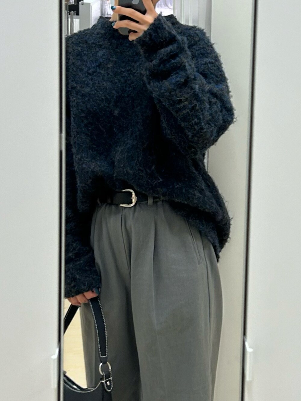 ブラック系のニット/セーター、グレー系のパンツ、ブラック系のベルトを着用したレディースの秋コーディネートの2枚目の写真