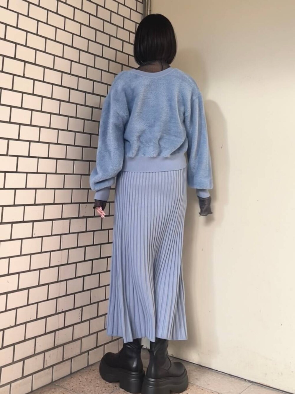 ホワイト系のブルゾン、ブラック系のブーツ、ブルー系のワンピースを着用したレディースの冬コーディネートの4枚目の写真