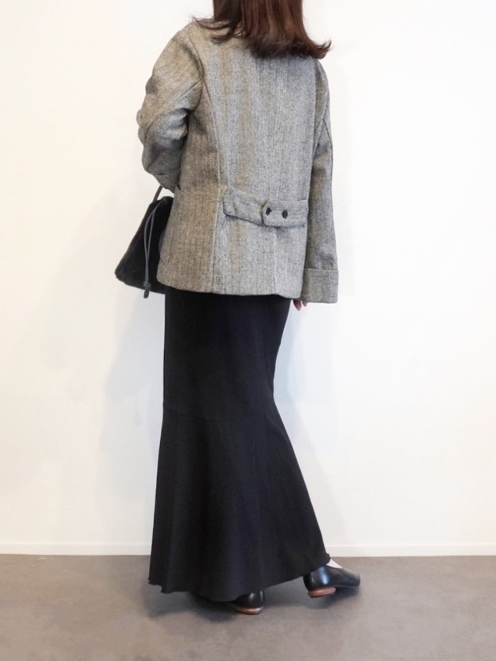 ブラック系のノーカラージャケット、グレー系のショルダーバッグ、ブラック系のパンプスを着用したレディースの秋コーディネートの2枚目の写真