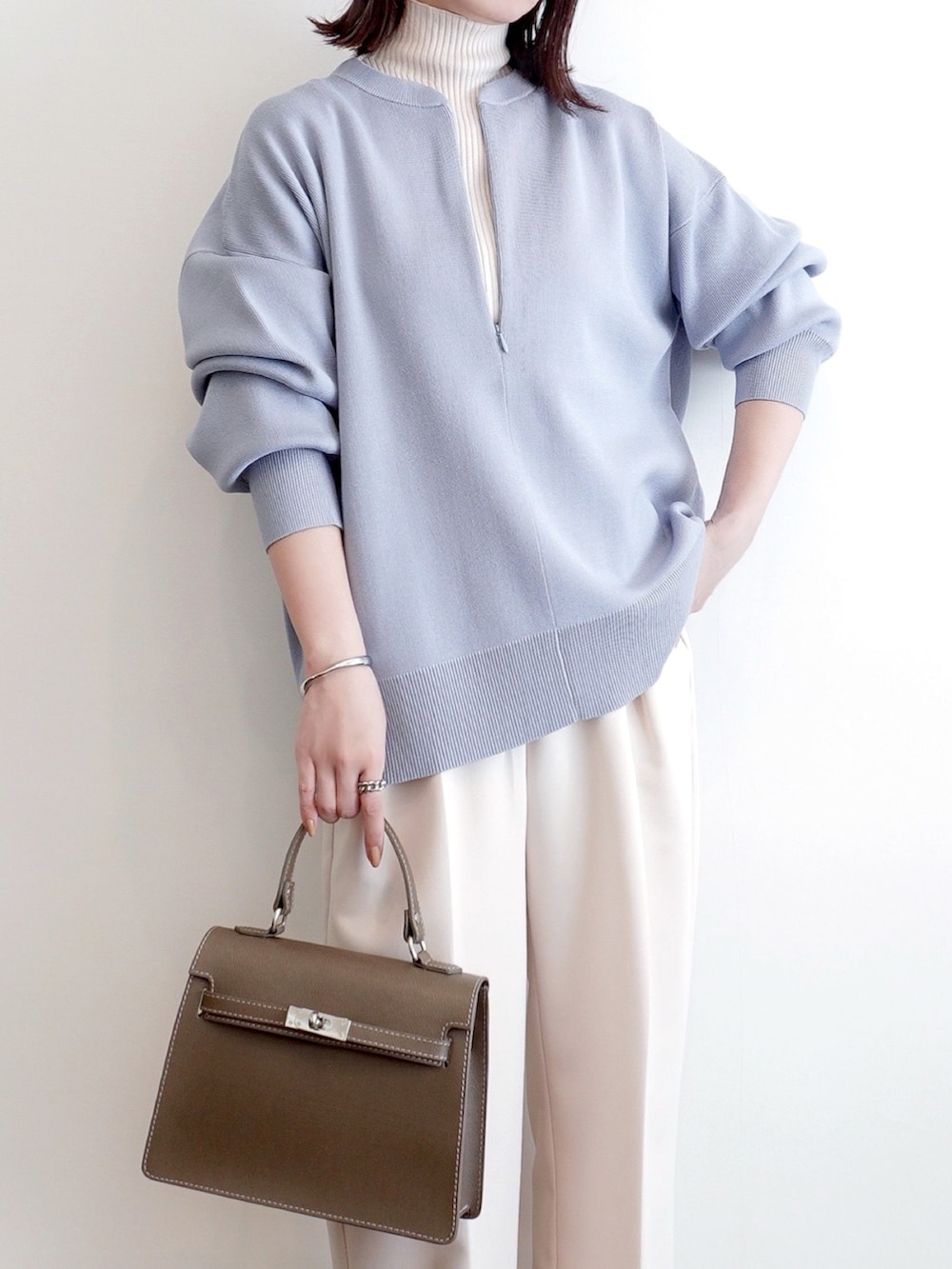 ブルー系のニット/セーター、ホワイト系のその他パンツ、グレー系のパンプスを着用したレディースの冬コーディネートの2枚目の写真