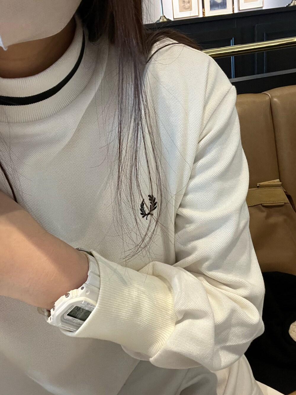 ブラック系のノーカラージャケット、ホワイト系のワンピース、ホワイト系のスニーカーを着用したレディースの冬コーディネートの2枚目の写真