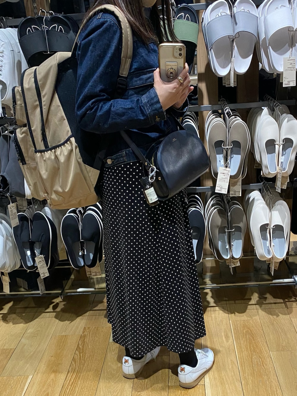 ブラック系のショルダーバッグ、ブラック系のスカート、ブルー系のデニムジャケットを着用したレディースの春コーディネートの2枚目の写真