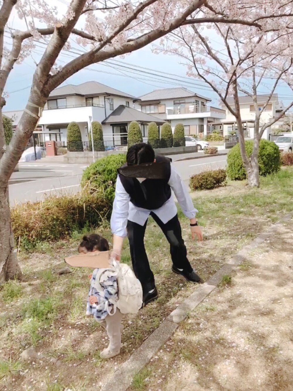 ブラック系のスラックス、ブラック系のベスト、ブルー系のシャツ/ブラウスを着用したメンズの春コーディネートの2枚目の写真