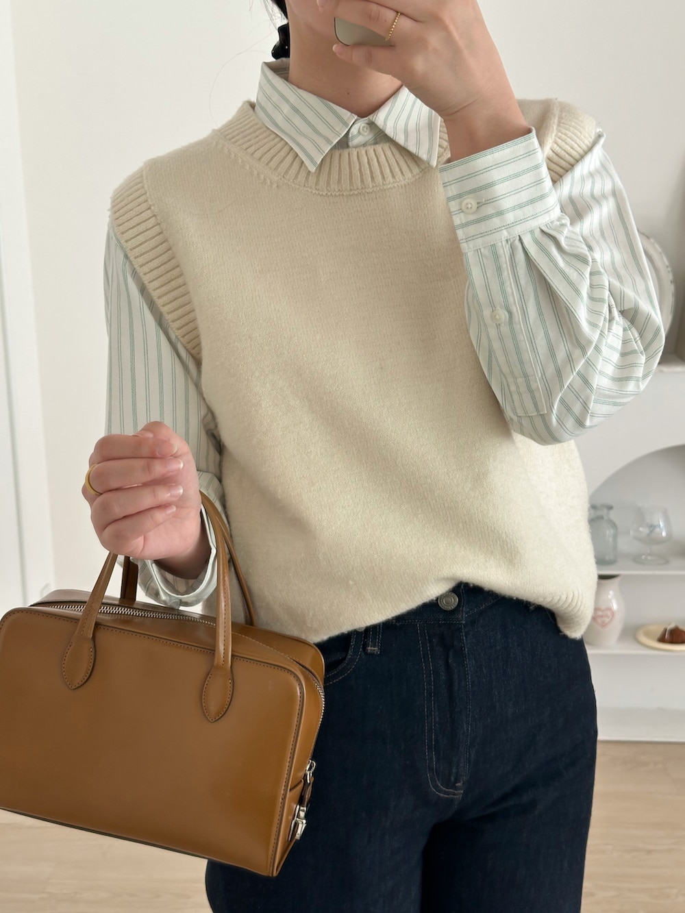 ブルー系のデニムパンツ、ホワイト系のベスト、ホワイト系のシャツ/ブラウスを着用したレディースの冬コーディネートの4枚目の写真