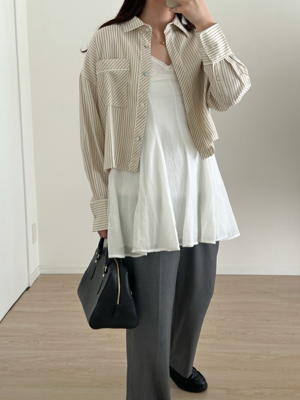 ホワイト系のワンピース/ドレス、グレー系のパンツ、ブラック系のバッグを着用したレディースの春コーディネートの3枚目の写真