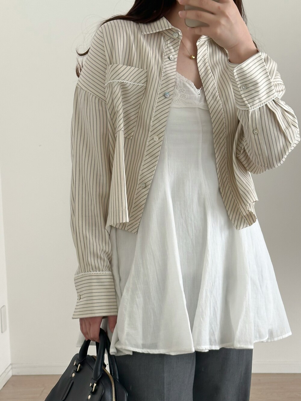 ホワイト系のワンピース/ドレス、グレー系のパンツ、ブラック系のバッグを着用したレディースの春コーディネートの4枚目の写真