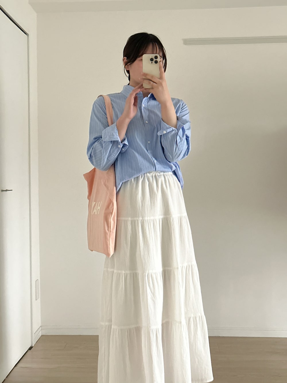 ホワイト系のスカート、ピンク系のトートバッグ、ブルー系のシャツ/ブラウスを着用したレディースの春コーディネートの3枚目の写真