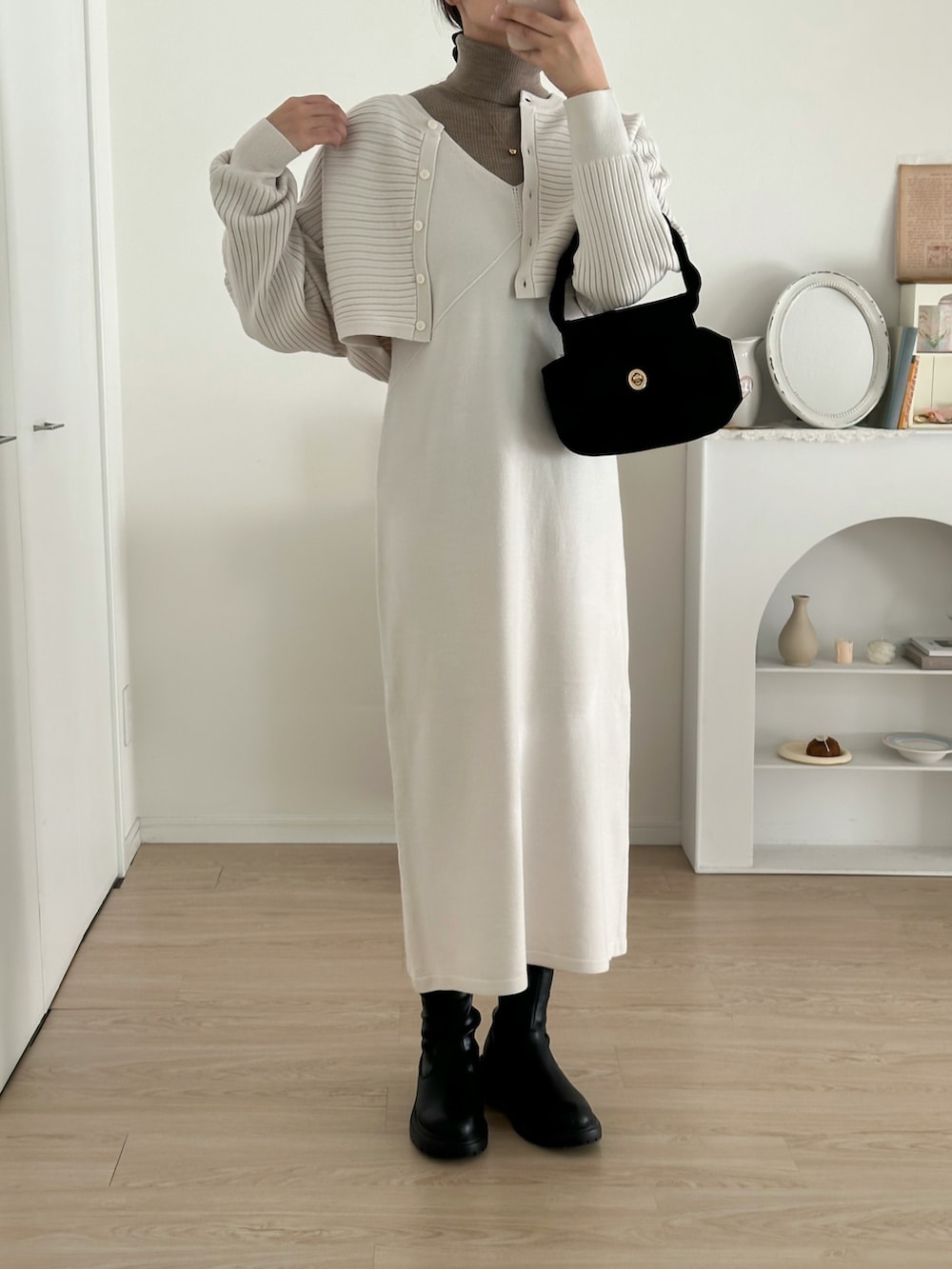 ブラック系のブーツ、ホワイト系のワンピース/ドレス、ブラウン系のニット/セーターを着用したレディースの冬コーディネートの3枚目の写真