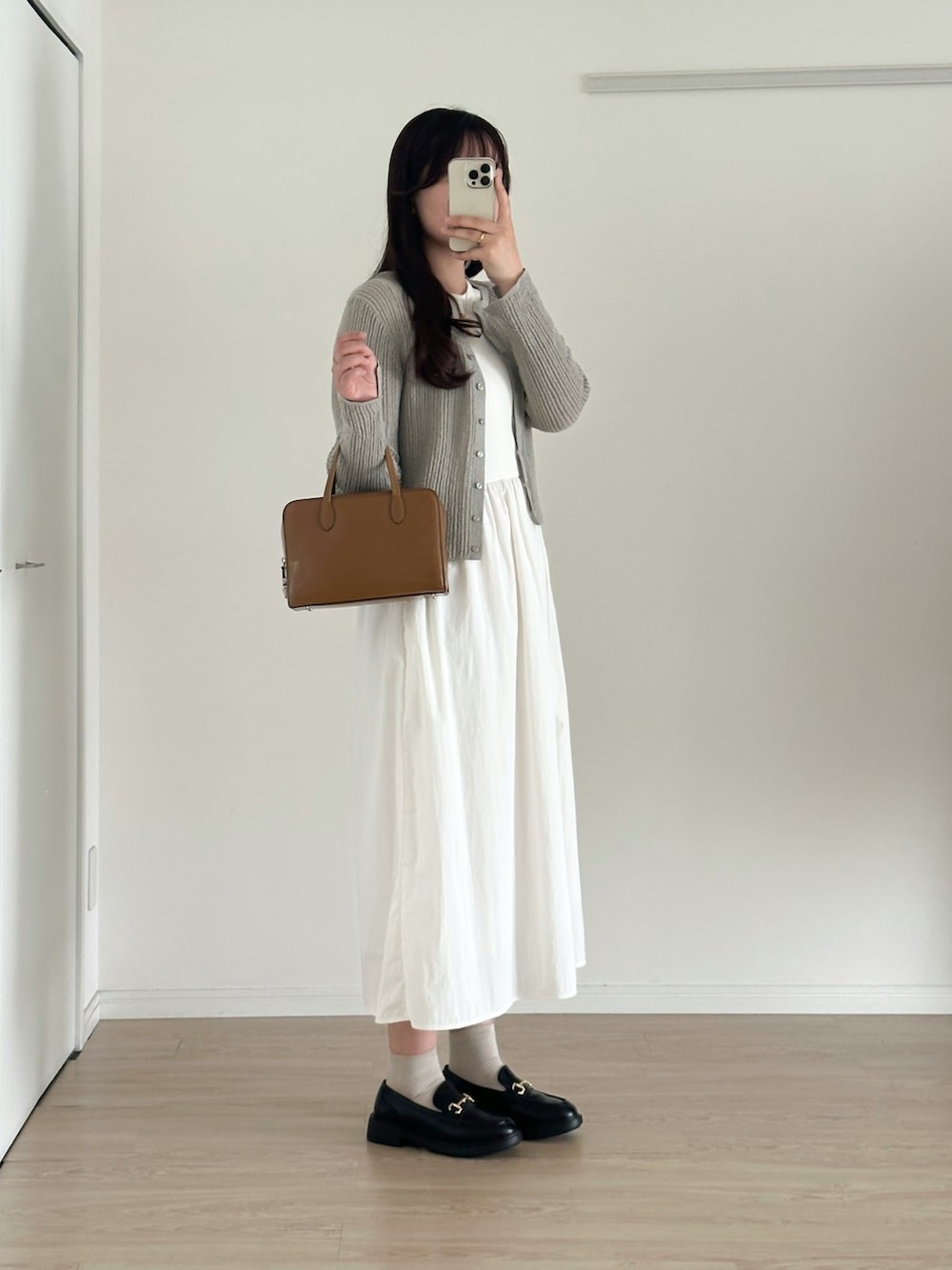 ブラック系のローファー、ブラウン系のバッグ、グレー系のカーディガン/ボレロを着用したレディースの夏コーディネートの2枚目の写真