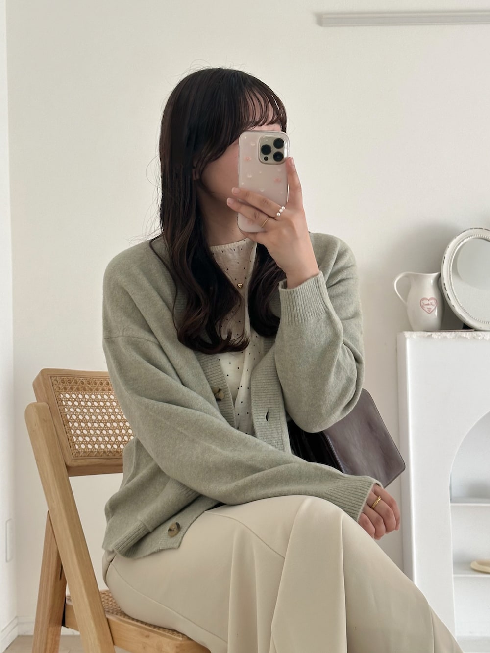 ブラック系のシューズ、ホワイト系のスカート、グリーン系のニット/セーターを着用したレディースの秋コーディネートの4枚目の写真