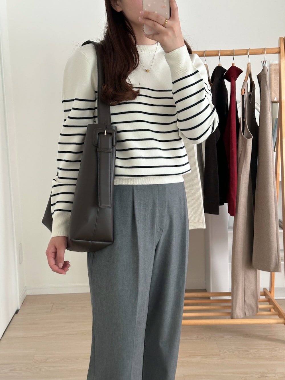 ホワイト系のニット/セーター、グレー系のパンツ、ブラウン系のバッグを着用したレディースの冬コーディネートの3枚目の写真